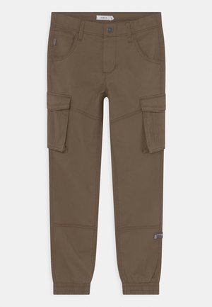Brune cargobukser med elastiske manchetter, frontknap- og lynlåslukning, sidelommer med klap og syningsdetaljer foran og bagpå.
