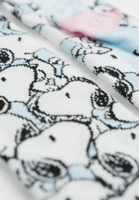 Tessuto bianco con un motivo ripetitivo di animali in stile cartone animato, nei colori nero e blu, con accenti di rosa e una texture morbida.