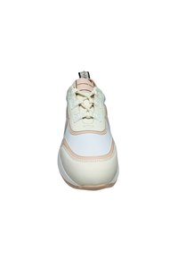 Cremefarbener und beiger Sneaker mit Schnürung vorne, dicker Sohle und markiertem Zuglasche vor weißem Hintergrund.