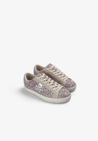 Zapatillas rosas brillantes con una lengüeta de lona beige, detalles plateados y cordones blancos. Presentan un logo de calavera en el lateral. Adecuadas para un look casual.