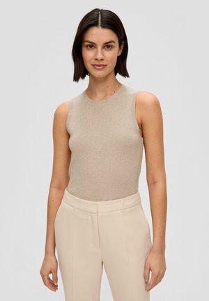 Beige ribgebreide mouwloze top met een ronde halslijn, gecombineerd met lichtbeige op maat gemaakte broeken. Zachte textuur, minimalistisch ontwerp.