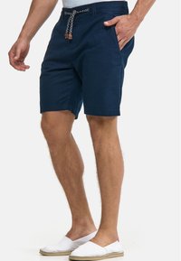 Shorts bleu marine en tissu léger avec une ceinture élastique, fermeture à cordon, poches latérales et coupe droite.