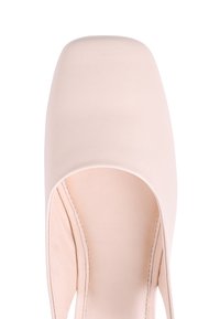 Zapato de tacón alto de cuero rosa claro con un diseño de punta cuadrada y lados recortados, que muestra una textura suave y un estilo minimalista.