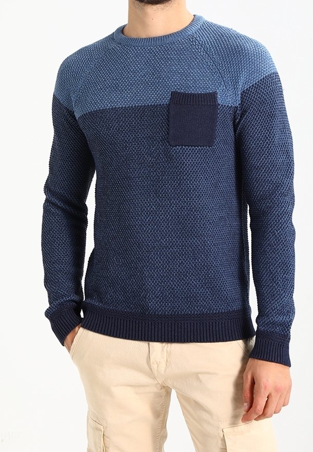Pull en maille bleu marine avec une finition texturée, comprenant une poche patch rectangulaire bleu clair et des détails en côtes aux poignets et à l'ourlet.