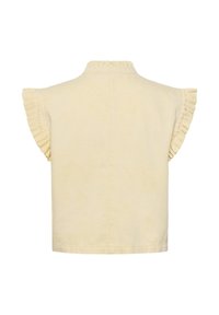 Beige ärmlös blus med volangkant på axlarna och hög krage, sedd bakifrån mot vit bakgrund.