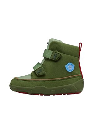 Olivgrüner High-Top-Sneaker mit zwei Klettverschlüssen, strukturierter Sohle, blauem runden Logo und rotem Stoffzuglasche an der Ferse.