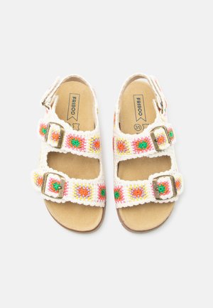 Barnefargede beige sandaler med fargerike heklede stropper med oransje og grønne blomstermønstre og justerbare metallspenner.