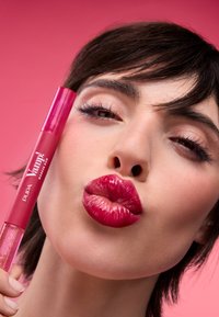 Il Pupa Vamp! Makeup Duo presenta un tubetto rosa lucido con un applicatore scintillante, che mostra labbra rosa vivaci e lucide su uno sfondo rosa.