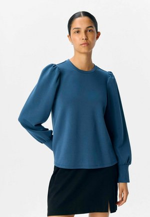 Felpa blu con maniche lunghe a sbuffo, scollo rotondo e vestibilità comoda. Realizzata in un tessuto liscio ed elastico.