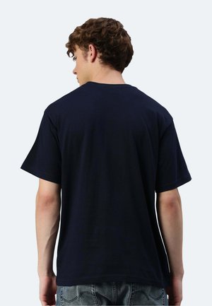 Navyblaue Baumwoll-T-Shirt mit lockerer Passform, kurzen Ärmeln und rundem Halsausschnitt, von hinten betrachtet. Weicher Stoff, minimale Details.