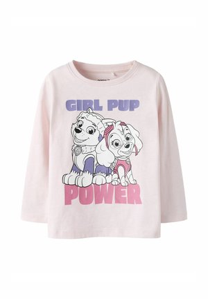 Chemise rose clair à manches longues avec deux chiots de dessin animé et le texte "GIRL PUP POWER" en lettres violettes et roses sur le devant.