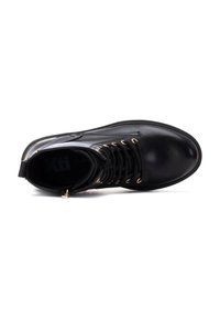 Botín negro con cordones hasta el tobillo, hecho de material sintético, con ojales dorados, textura suave y diseño de punta redonda.