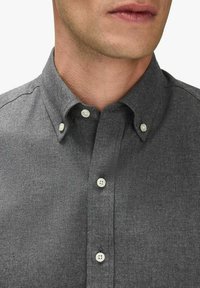 Mörkgrå skjorta med krage, små vita knappar och en texturerad tyg. Designen har en enkel, klassisk stil.