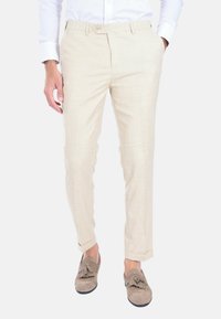 Pantaloni beige slim fit realizzati in tessuto leggero, con una superficie leggermente strutturata, chiusura a un bottone e orli risvoltati.