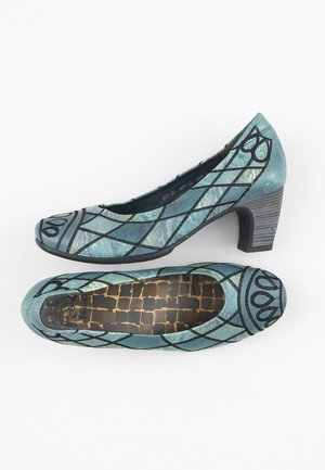 Chaussures à talon moyen en daim bleu sarcelle pour femme, avec motif noir en losange et goutte, bouts arrondis et semelles intérieures marron à motifs.