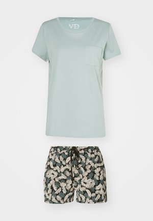 Light green cotton T-shirt with round neckline and chest pocket, paired with black shorts featuring a palm leaf pattern in cream and green.