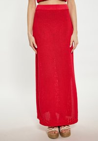 Rode gehaakte maxi rok met een hoge tailleband en zijsplitsen, met een gestructureerd open breipatroon en een vloeiende silhoeet.
