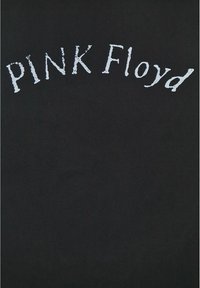 Černé tričko s potiskem "PINK Floyd" v opotřebovaném bílém písmu uspořádaném do oblouku přes oblast hrudníku. Měkká, hladká textura.