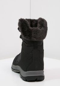 Black winter boot with thick gray fur lining, sturdy sole, and secure fastenings, angled to show back and side details.