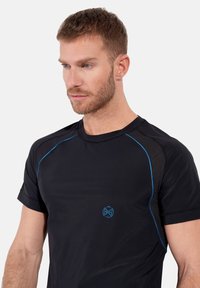 Svart atletisk t-shirt med blå accenter, korta ärmar, rund hals och logodetalj på bröstet. Tillverkad av andningsbart tyg.