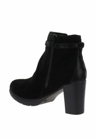 Botte de cheville en suede noir avec un talon haut épais, une fermeture éclair sur le côté et un détail de bande texturée autour de la cheville.