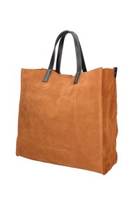 Bruin suede tote bag met zwarte leren handvatten, rechthoekige vorm, minimale stikdetails en open bovenkant voor gemakkelijke toegang.