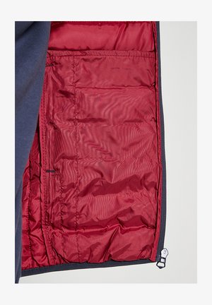 Donkerblauwe buitenstof met een zachte textuur, met een felrode geïsoleerde voering. Voorzien van een rits en binnenzakken voor opbergruimte.