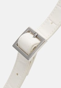 Biały pasek z sztucznej skóry o wzorze krokodyla z prostokątną metalową klamrą w kolorze srebrnym, częściowo przewinięty przez klamrę.