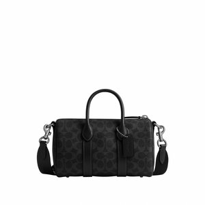 Sort mønstret læderhåndtaske med dobbelte håndtag, aftagelig skulderrem og et lille hængende mærke fastgjort til et af håndtagene.