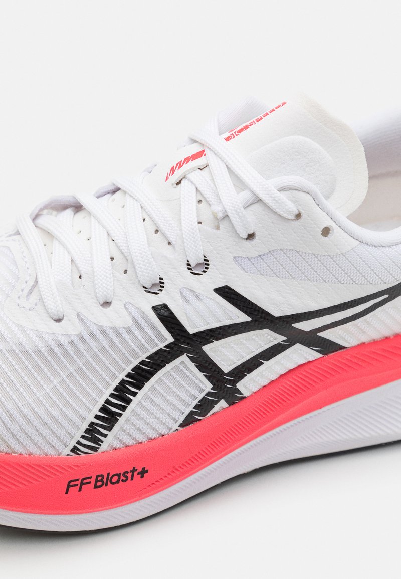 Baskets de sport blanches avec une tige texturée, des logos noirs sur les côtés et une semelle intermédiaire rose vif avec la marque "FF Blast+".