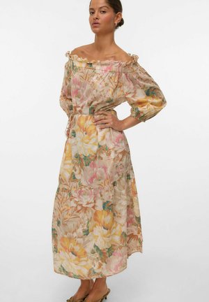 Robe maxi florale en tissu léger, présentant un design épaules dénudées, un col élastique et un ourlet asymétrique avec des couleurs pastel et des motifs botaniques.
