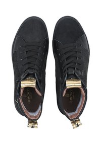 Schwarze Knöchelsneaker aus Wildleder und Stoff, mit einer strukturierten Seite, goldenen Akzenten an der Ferse und flachen schwarzen Schnürsenkeln.
