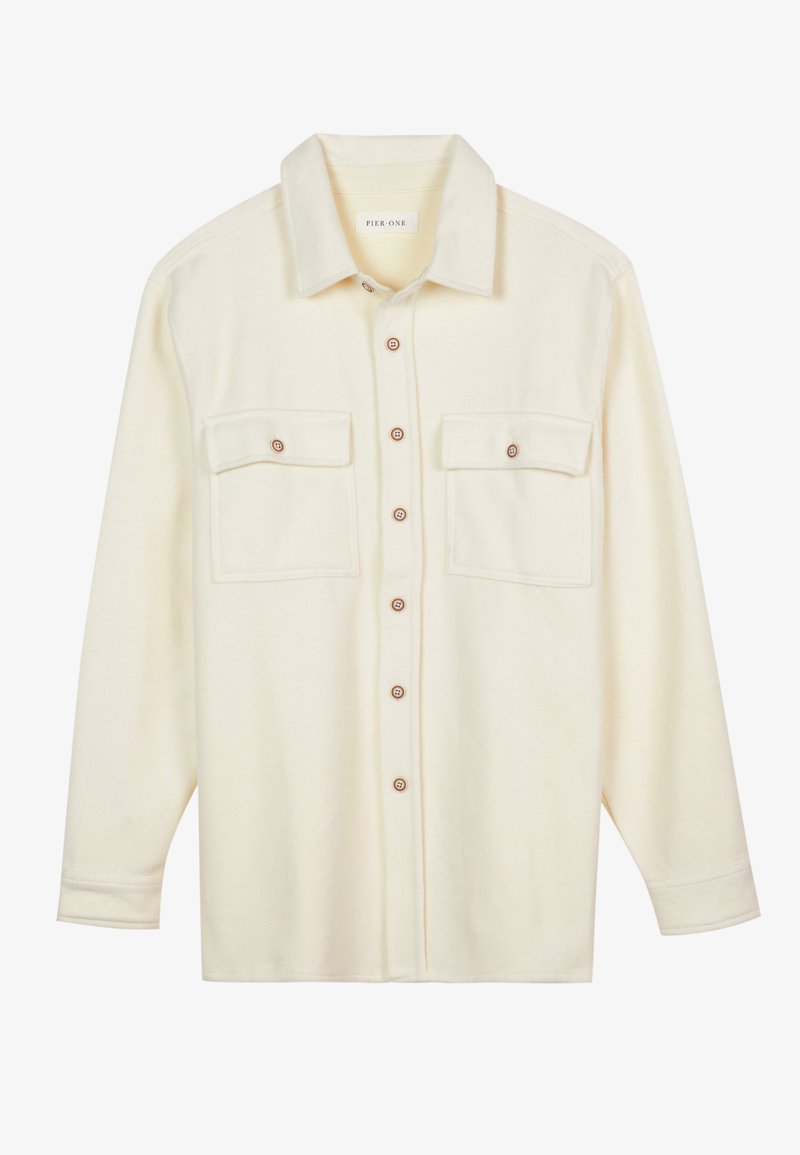 Cream-colored button-up shirt made of soft fabric. Features two chest pockets, a collared neckline, and brown buttons. Standard long sleeves.