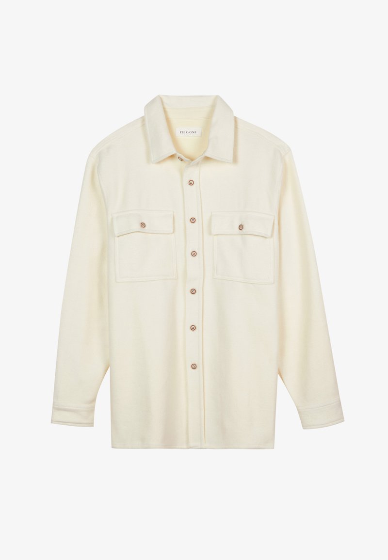 Cream-colored button-up shirt made of soft fabric. Features two chest pockets, a collared neckline, and brown buttons. Standard long sleeves.