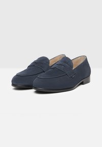 Marineblaue Wildleder-Slipper mit einer glatten Oberfläche, ausgestattet mit einem genähten Mokassinstil und einer niedrigen, flachen schwarzen Gummisohle.