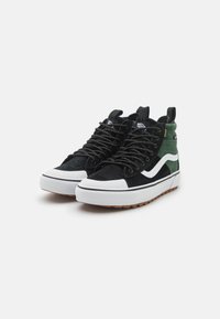 Sneakers alte in suede nero e verde, con strisce laterali bianche, lacci tondi e suola in gomma testurizzata. Accentuati con il logo.