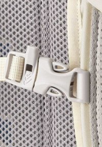 Gray mesh fabric with a plastic clip and beaded texture, featuring a creamy strap and a small viewing window on the buckle.
