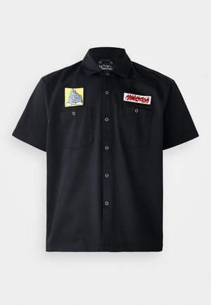 Schwarzes Kurzarmhemd mit zwei gestickten Patches auf der Brust: einem gelben Bergdesign und einem roten Textpatch. Vorderseitige Druckknopfverschlüsse.
