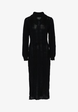 Czarna dzianinowa sukienka z kołnierzem szalowym, długimi rękawami i paskiem w talii. Charakteryzuje się teksturowanym splotem w warkocze. Sylwetka pełnej długości.