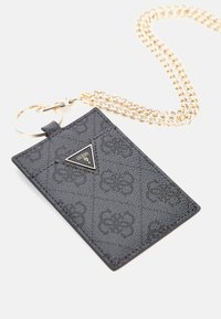 Zwart gestructureerd creditcardhouder met gouden ketting. Bevat een driehoekig logo-label en sleutelhanger. Subtiel logo patroon is op het oppervlak geperst.