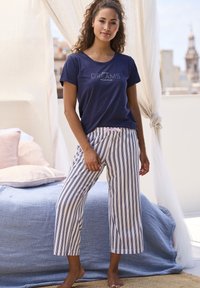 Navy cotton t-shirt with “DREAMS” text; white and navy striped cropped pants with a pink drawstring waistband. Floor-length, relaxed fit.
