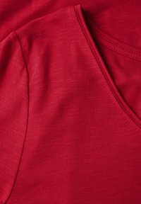 Rød V-hals T-shirt lavet af blødt, tekstureret stof, med et afslappet design og ren finish på kanterne.