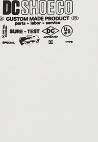 Etykieta firmy DC Shoe Co. przedstawiająca usługi dostosowywania produktów, zatwierdzenie Sure-Test oraz oznaczenia certyfikacji amerykańskiej na białym tle.