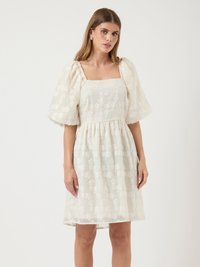 Weißes kurzes Kleid mit Puffärmeln, quadratischem Ausschnitt und texturiertem Blumenmuster. Leichter Stoff, geraffte Taille, knielanger Saum.