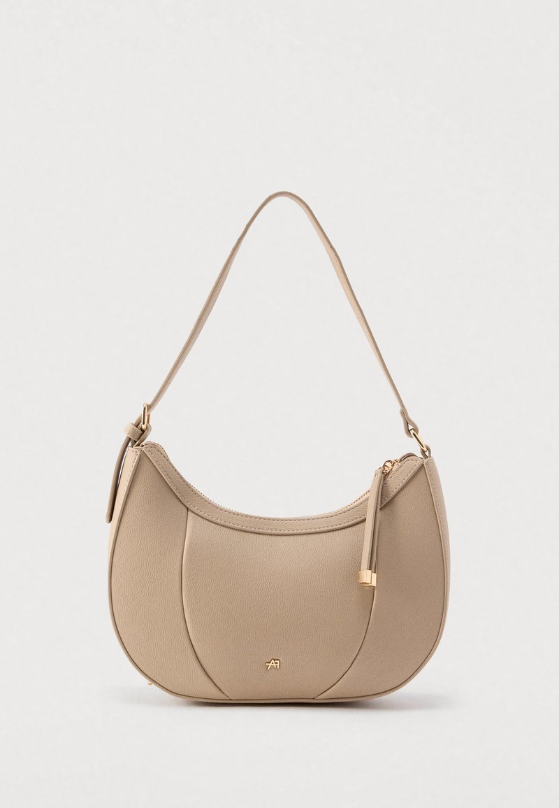 Borsa a tracolla in similpelle beige con silhouette curva, ferrature dorate e cerniera con dettaglio nappina. Texture liscia, design minimalista.