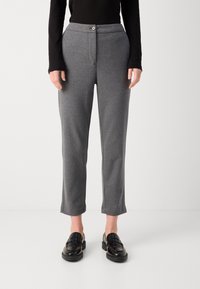 Grå skreddersydde bukser laget av myk stoff, med knappelukking, frontlommer og en cropped kant. Kombinert med svarte loafers.