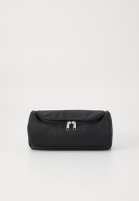 Black cylindrical bag made of textured fabric, featuring a flap closure and two silver zipper pulls. Compact design, no visible patterns.