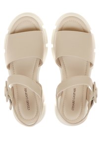 Beige platform sandaalit, joissa on leveät hihnat ja säädettävä solki. Sileä pinta, pehmustettu pohja ja kontrastivärinen valkoinen kumipohja.