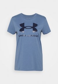 Modrá bavlněná trička s kulatým výstřihem, krátkými rukávy a velkým tmavě modrým logem. Pod logem je natištěno "UNDER ARMOUR" v reflexním provedení.
