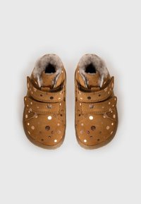 Botas de ante marrón con un forro de felpa, que presentan lunares metálicos y dos correas ajustables para el cierre. Punta redondeada y textura suave.